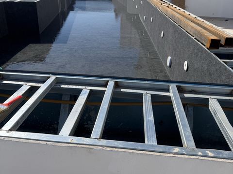 Πισίνα υπερχείλισης με σκούρο liner και πλαίσιο για τη σχάρα του καναλιού